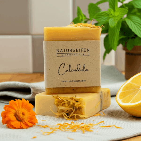 Seifenstück mit Ringelblumenblüten und einem Etikett mit der Aufschrift 'Calendula'.